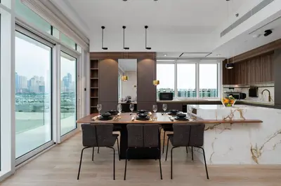 a kitchen with a large wooden table and chairs at Maison Privee - Deluxe 3BR Apt with Dubai Marina Vws & Beach Access in Dubai