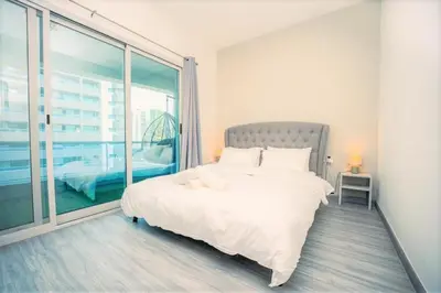 a bedroom with a large white bed and a large window at Royal Casa- Marina Diamond 2 in Dubai