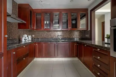 a kitchen with wooden cabinets and black counter tops at GuestReady - Sweet Sunshine in Downtown in Dubai