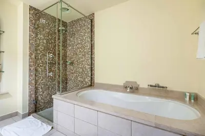 a bathroom with a tub and a glass shower at GuestReady - Sweet Sunshine in Downtown in Dubai