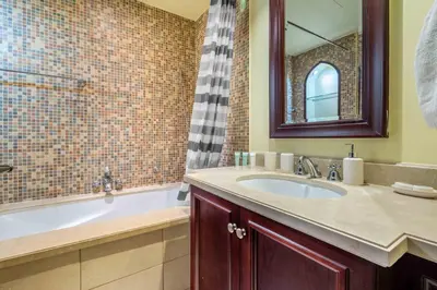 a bathroom with a tub and a sink and a mirror at GuestReady - Sweet Sunshine in Downtown in Dubai