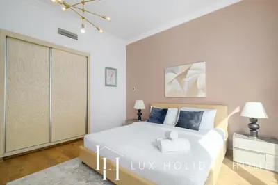 a bedroom with a large white bed and a closet at LUX The JBR Beach Sea View Suite in Dubai