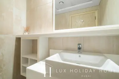 a bathroom with a white sink and a mirror at LUX The JBR Beach Sea View Suite in Dubai