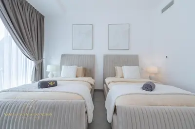 two beds in a room with white walls and windows at Marco Polo - Wake up to stunning sea views at Stella Maris in Dubai