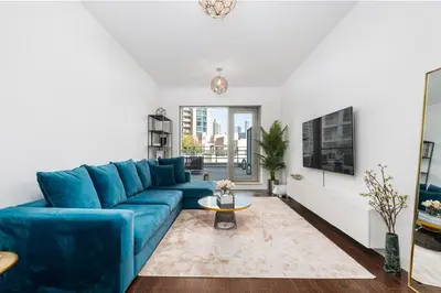 a living room with a blue couch and a table at Stylish and Central 1 BD in Downtown Dubai in Dubai