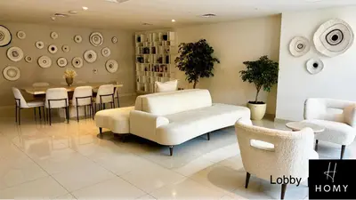 a living room with a couch and a table and chairs at Enjoy a Modern and Trendy apartment in the Heart of Dubai in Dubai