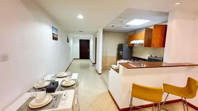 a kitchen with a table and chairs in a room at Spacious studio apartment in Dubai Marina close to metro and beach in Dubai