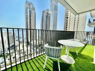 a balcony with a table and chairs and a view of the city at Elegant & Chic 2bedroom balcony Creek Waterfront in Dubai