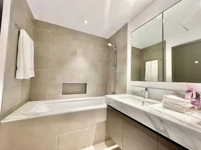 a bathroom with a tub and a sink and a mirror at Elegant & Chic 2bedroom balcony Creek Waterfront in Dubai
