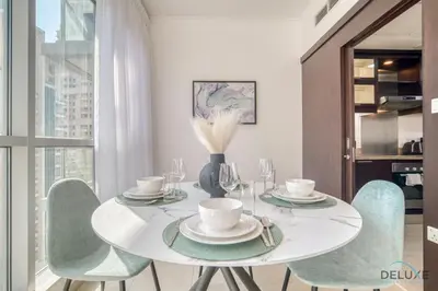 a dining room with a white table and chairs at Glamorous 1BR at Residences 5 Downtown Dubai by Deluxe Holiday Homes in Dubai