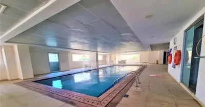 a large swimming pool in a large building at Upgraded 1 Bhk Silicon Oasis Short or long rental in Dubai
