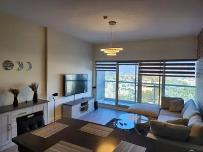 a living room with a couch and a tv at Upgraded 1 Bhk Silicon Oasis Short or long rental in Dubai