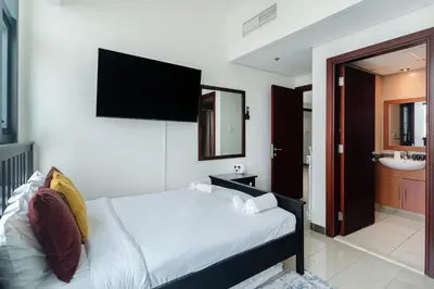a bedroom with a bed with a television on the wall at Scenic lake view 2BR near metro in Cluster A, JLT - Allsopp&Allsopp in Dubai