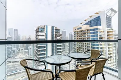 a balcony with tables and chairs and a view of the city at Scenic lake view 2BR near metro in Cluster A, JLT - Allsopp&Allsopp in Dubai