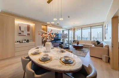 a dining room and living room with a table and chairs at EDEN'S Homes & Villas - Boulevard Point in Dubai