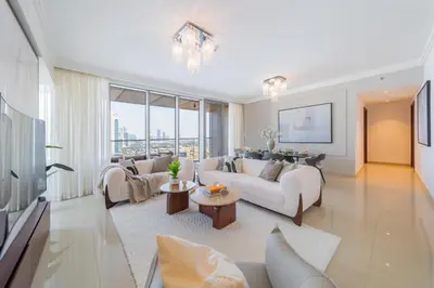 a living room with white furniture and a large window at EDEN'S Homes & Villas - Boulevard Point in Dubai