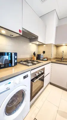 a kitchen with a washing machine and a stove at STAY BY LATINEM Luxury 1BR Holiday Home CVR A2609 near Burj Khalifa in Dubai