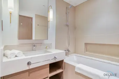 a white bathroom with a tub and a sink at Captivating 1BR at 17 Icon Bay Dubai Creek Harbour by Deluxe Holiday Homes in Dubai