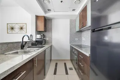 a kitchen with a sink and a stainless steel refrigerator at StoneTree - Park Island Blakely 1 BR - Prime location in Dubai