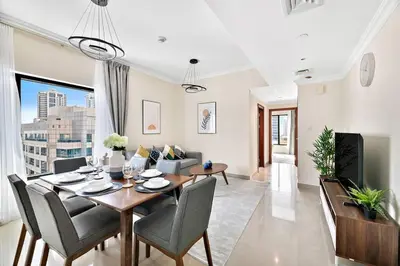 a dining room and living room with a table and chairs at StoneTree - Time Place Tower 1 BR - Amazing View in Dubai