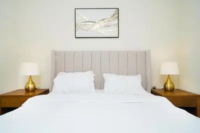 a bedroom with a large white bed with two lamps at AMAKIN Burj Vista Tower 1 in Dubai