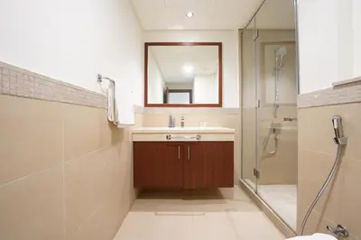 a bathroom with a sink and a shower with a mirror at AMAKIN Burj Vista Tower 1 in Dubai