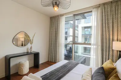 a bedroom with a bed and a large window at HiGuests - Charming Retreat in CityWalk With Balcony and Pool in Dubai