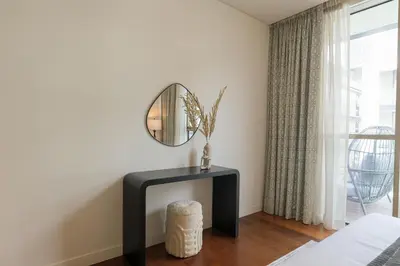 a living room with a mirror and a table at HiGuests - Charming Retreat in CityWalk With Balcony and Pool in Dubai