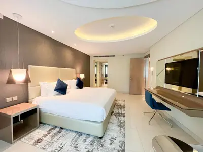 a bedroom with a large bed and a flat screen tv at Luton Vacation Homes - Damac Tower By Paramount - Business Bay, Dubai - 80AB4 in Dubai