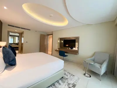 a bedroom with a bed and a tv and a chair at Luton Vacation Homes - Damac Tower By Paramount - Business Bay, Dubai - 80AB4 in Dubai