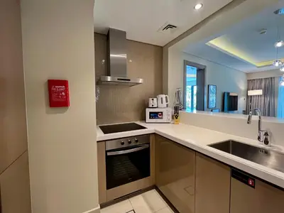 a kitchen with a sink and a stove top oven at Luton Vacation Homes - Damac Tower By Paramount - Business Bay, Dubai - 80AB4 in Dubai