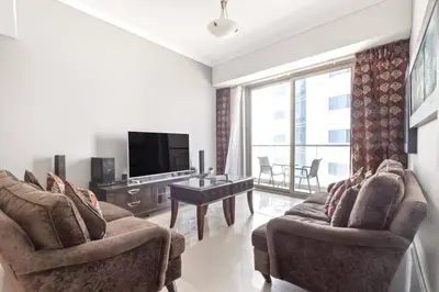 a living room with two chairs and a flat screen tv at StoneTree - Ocean Heights 1 BR - High Floor in Dubai