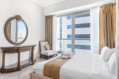 a bedroom with a bed and a mirror and a window at StoneTree - Ocean Heights 1 BR - High Floor in Dubai