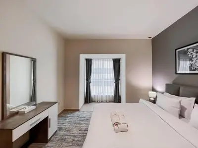a bedroom with a large white bed and a television at StoneTree - Elite Residence 1 BR - Near Dubai Tram in Dubai