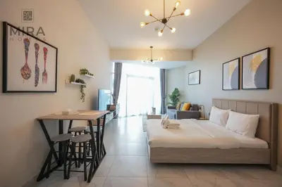a bedroom with a bed and a table in it at Mira Holiday Homes - Fully furnished Studio in Business Bay in Dubai