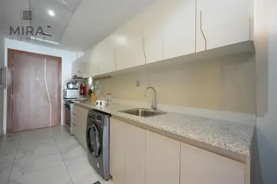a kitchen with a sink and a washing machine at Mira Holiday Homes - Fully furnished Studio in Business Bay in Dubai