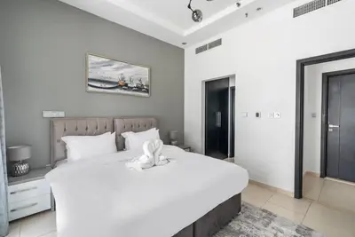 a bedroom with a large white bed with a towel on it at StoneTree - SkyView Tower 1 BR - Best Location in Dubai