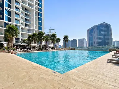 a swimming pool in a city with tall buildings at ALiving Elegant Studio with Balcony I Canal View I DAMAC Maison Prive- 706B in Dubai