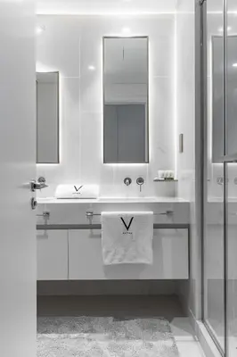 a white bathroom with a sink and a mirror at Sea View with Private Beach Access! 3BR & Maid Rm in Dubai