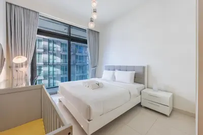 a bedroom with a white bed and a large window at Sea View with Private Beach Access! 3BR & Maid Rm in Dubai
