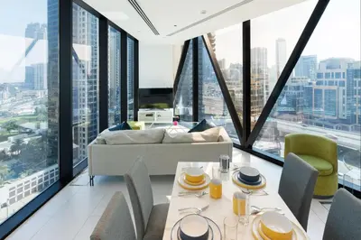 a living room with a couch and tables and chairs at Marquise Square - 2Br Apartment - Allsopp&Allsopp in Dubai