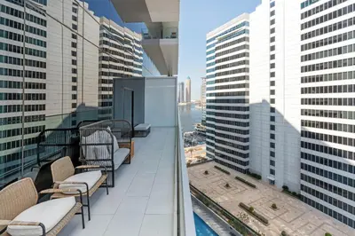 a balcony with chairs and a view of a city at Marquise Square - 2Br Apartment - Allsopp&Allsopp in Dubai