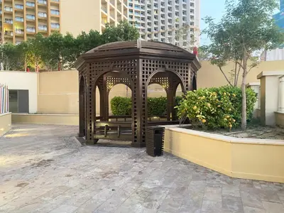 a gazebo with a bench in a courtyard at JBR Beach - Panoramic Sea View 2BR Apartment in Dubai