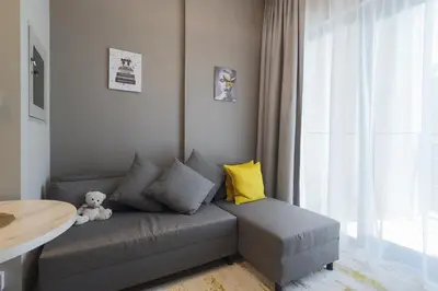 a teddy bear sitting on a couch in a living room at Business Bay 1 bedroom with Canal view in Dubai