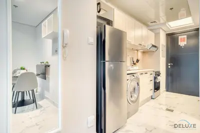 a kitchen with a refrigerator and a washing machine at Classic 1BR at MAG 510 Dubai South by Deluxe Holiday Homes in Dubai