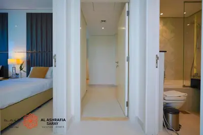 a bedroom with a bed and a bathroom with a toilet at Alashrafia Saray - Spectacular 2BR in Canal Views in Dubai