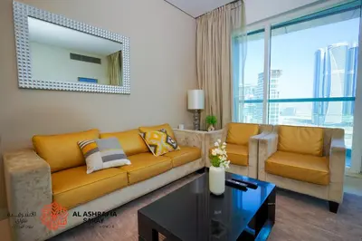a living room with a couch and a table at Alashrafia Saray - Spectacular 2BR in Canal Views in Dubai