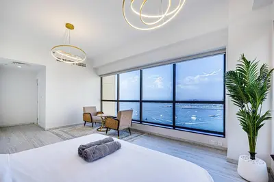 a bedroom with a large white bed and a large window at JBR 3 bedroom apartment with fantastic ocean view in Dubai