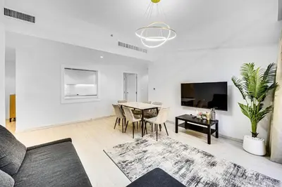 a living room with a table and a tv at JBR 3 bedroom apartment with fantastic ocean view in Dubai