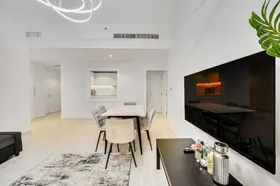 a living room with a table and chairs and a tv at JBR 3 bedroom apartment with fantastic ocean view in Dubai